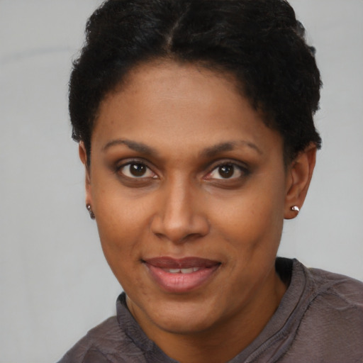 Joyful black adult female with short  brown hair and brown eyes