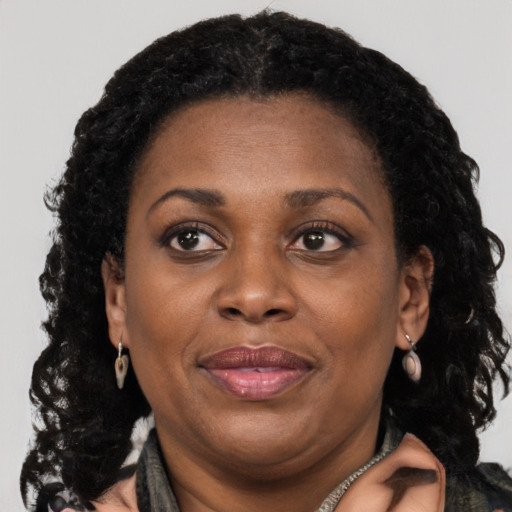 Joyful black adult female with long  brown hair and brown eyes