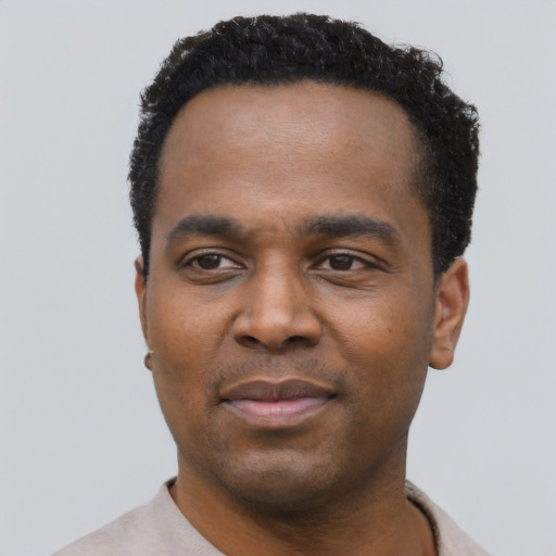 Joyful black young-adult male with short  black hair and brown eyes