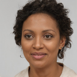 Joyful black adult female with medium  brown hair and brown eyes