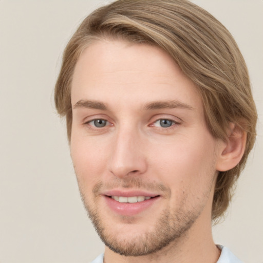 Joyful white young-adult male with short  brown hair and green eyes