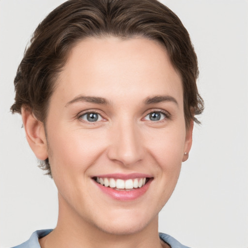 Joyful white young-adult female with short  brown hair and grey eyes