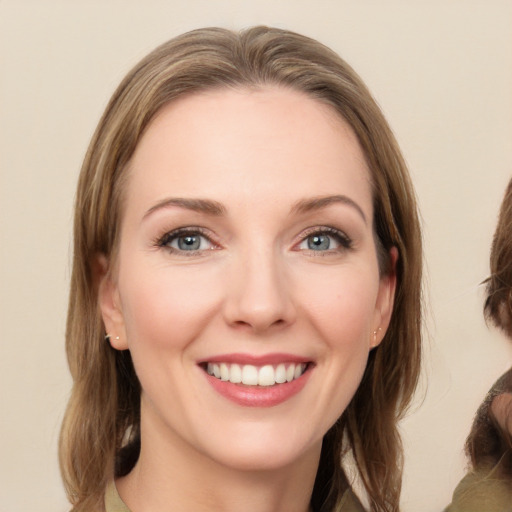 Joyful white young-adult female with medium  brown hair and green eyes