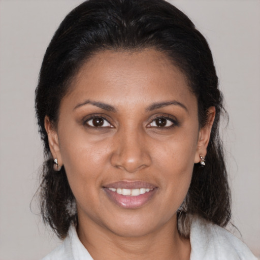 Joyful black adult female with medium  brown hair and brown eyes