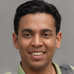 Joyful latino young-adult male with short  black hair and brown eyes