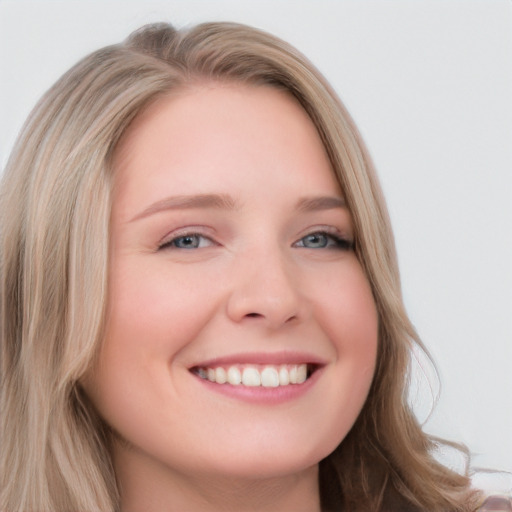 Joyful white young-adult female with long  blond hair and blue eyes