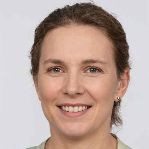 Joyful white adult female with medium  brown hair and grey eyes