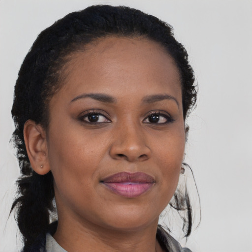 Joyful black young-adult female with long  brown hair and brown eyes