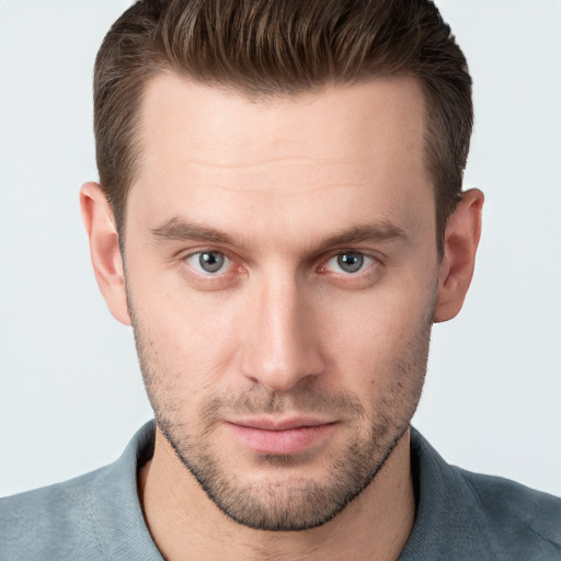 Joyful white young-adult male with short  brown hair and grey eyes