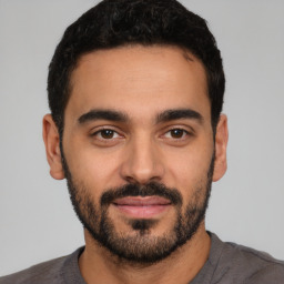 Joyful latino young-adult male with short  black hair and brown eyes