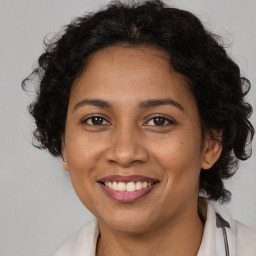 Joyful latino adult female with medium  brown hair and brown eyes