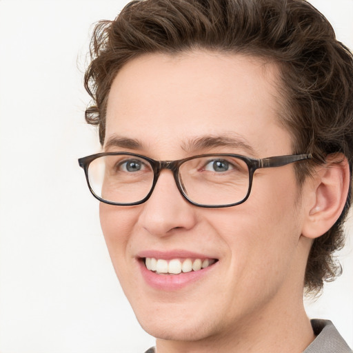 Joyful white young-adult male with medium  brown hair and green eyes