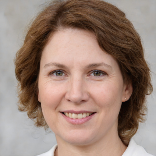 Joyful white adult female with medium  brown hair and green eyes