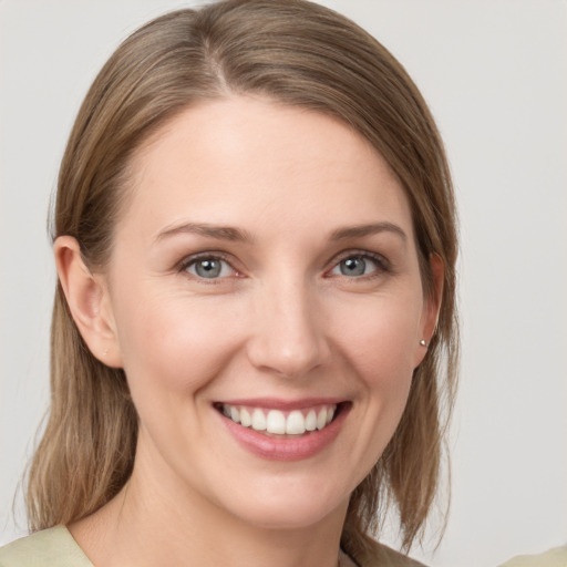 Joyful white young-adult female with medium  brown hair and grey eyes