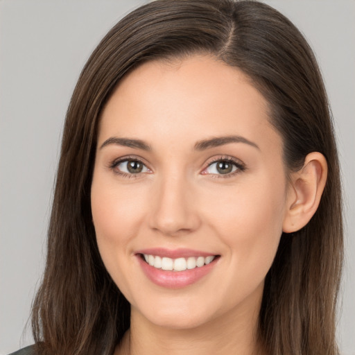 Joyful white young-adult female with long  brown hair and brown eyes