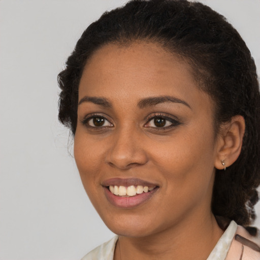 Joyful black young-adult female with short  brown hair and brown eyes