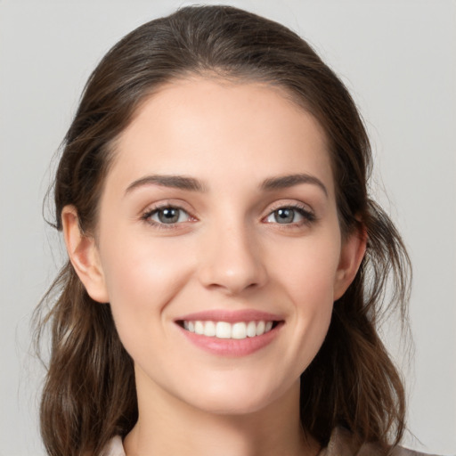 Joyful white young-adult female with medium  brown hair and grey eyes