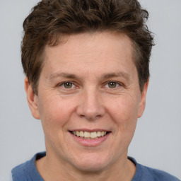 Joyful white adult male with short  brown hair and grey eyes