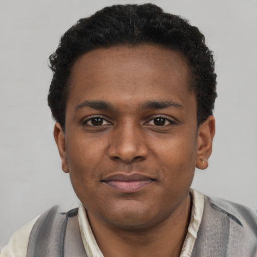 Joyful black young-adult male with short  brown hair and brown eyes