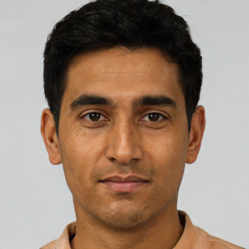 Joyful latino young-adult male with short  black hair and brown eyes