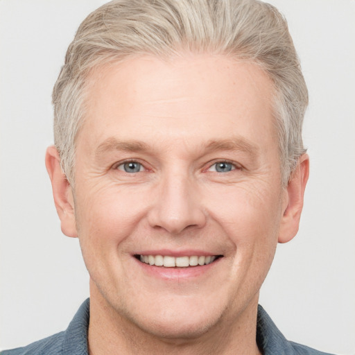 Joyful white adult male with short  blond hair and grey eyes