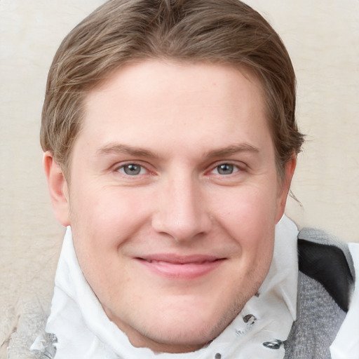 Joyful white young-adult male with short  brown hair and blue eyes