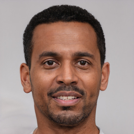 Joyful black young-adult male with short  brown hair and brown eyes