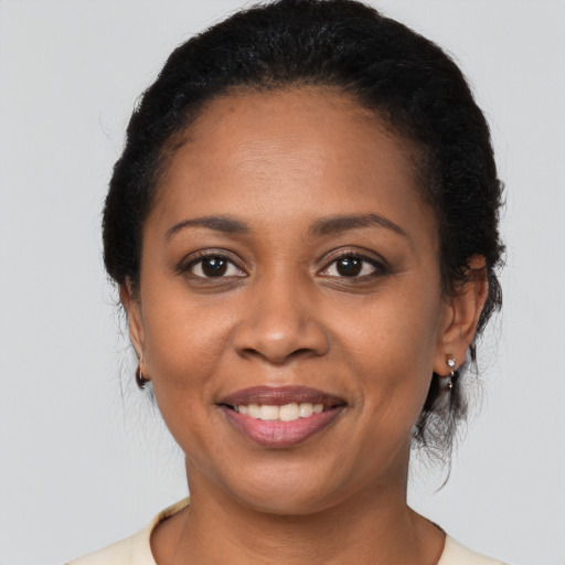 Joyful black young-adult female with medium  black hair and brown eyes
