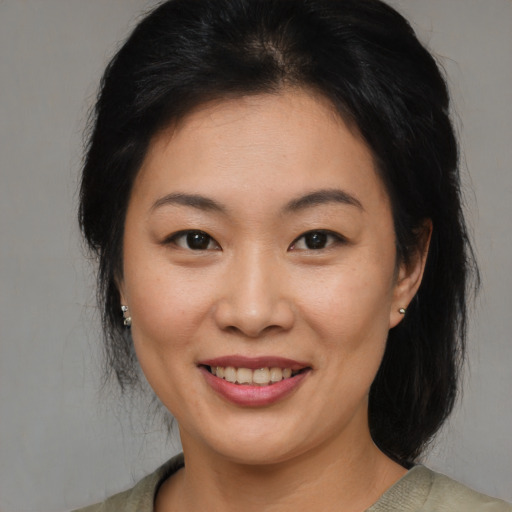 Joyful asian young-adult female with medium  brown hair and brown eyes