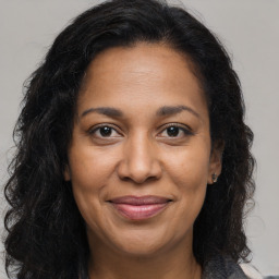 Joyful black adult female with long  brown hair and brown eyes