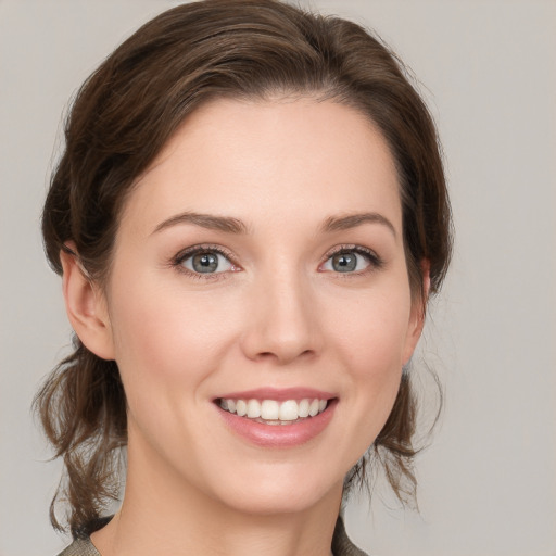 Joyful white young-adult female with medium  brown hair and grey eyes