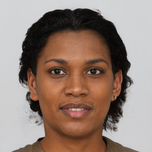 Joyful black young-adult female with short  black hair and brown eyes