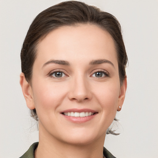 Joyful white young-adult female with medium  brown hair and grey eyes