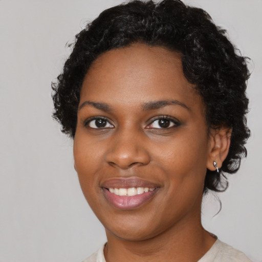 Joyful black young-adult female with short  black hair and brown eyes