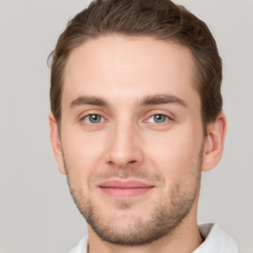 Joyful white young-adult male with short  brown hair and grey eyes