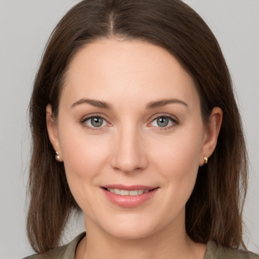 Joyful white young-adult female with medium  brown hair and grey eyes