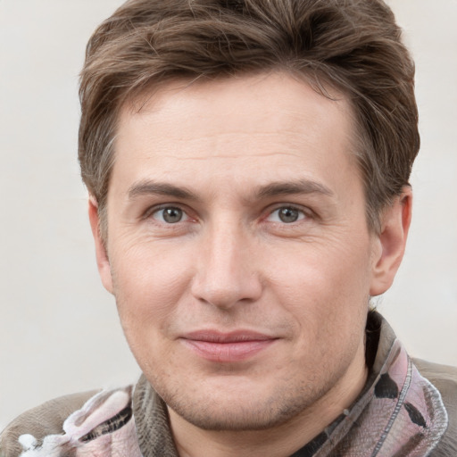 Joyful white young-adult male with short  brown hair and grey eyes