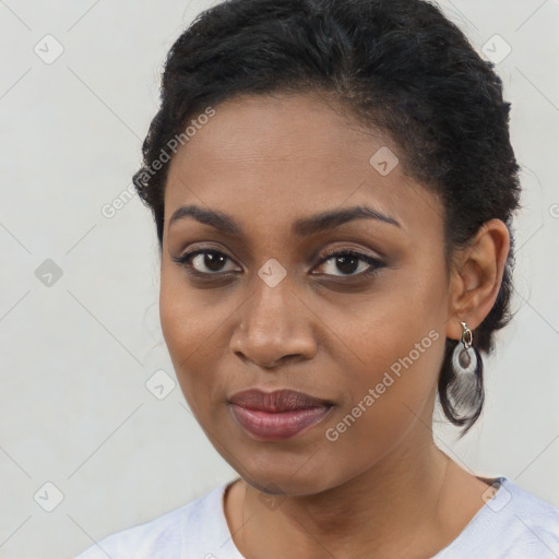 Joyful black young-adult female with long  black hair and brown eyes