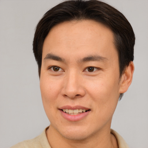 Joyful asian young-adult male with short  brown hair and brown eyes