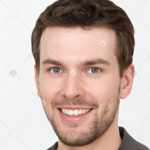 Joyful white young-adult male with short  brown hair and grey eyes