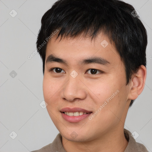 Joyful asian young-adult male with short  brown hair and brown eyes