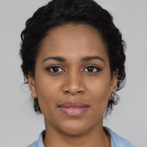 Joyful black young-adult female with medium  black hair and brown eyes