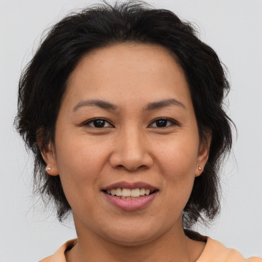 Joyful asian adult female with medium  brown hair and brown eyes