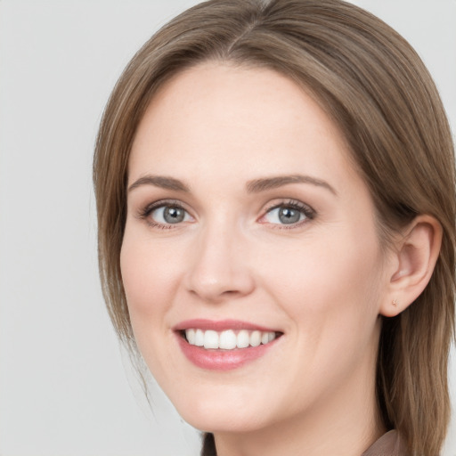 Joyful white young-adult female with long  brown hair and grey eyes