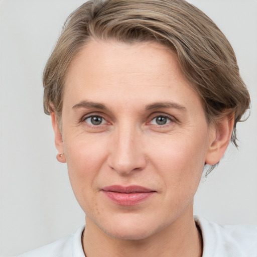 Joyful white adult female with short  brown hair and grey eyes