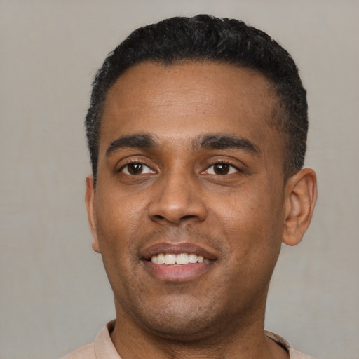 Joyful latino young-adult male with short  black hair and brown eyes