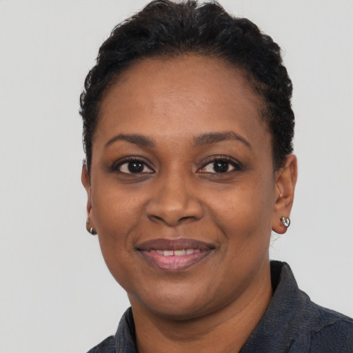 Joyful black young-adult female with short  black hair and brown eyes