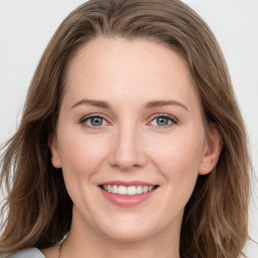 Joyful white young-adult female with long  brown hair and blue eyes