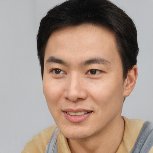 Joyful asian young-adult male with short  brown hair and brown eyes