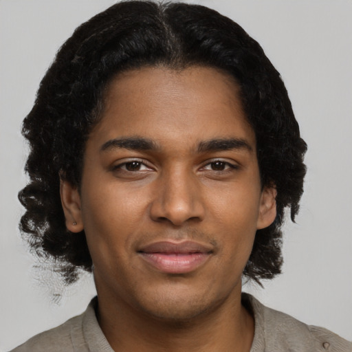 Joyful black young-adult male with short  brown hair and brown eyes